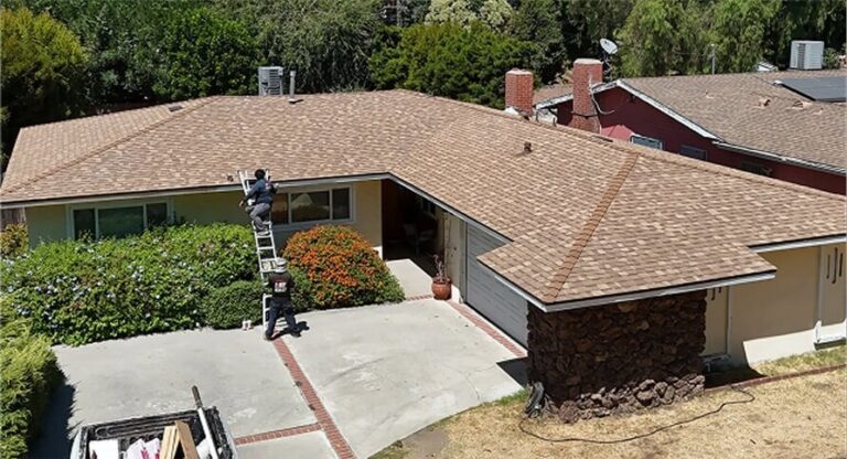 Roofing technicians inspecting and repairing shingles on a suburban single-family home.