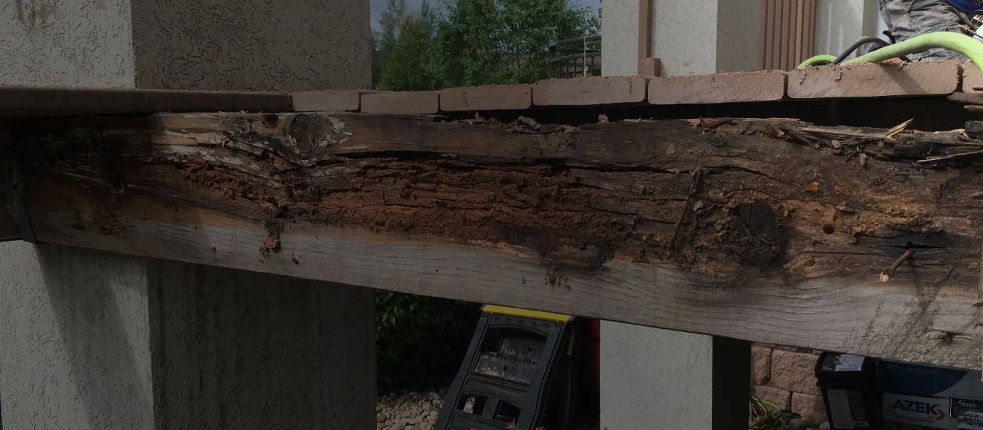 Severely rotted exterior beam and fascia board caused by long-term water intrusion, illustrating RainWise dry rot removal and roofline reconstruction services