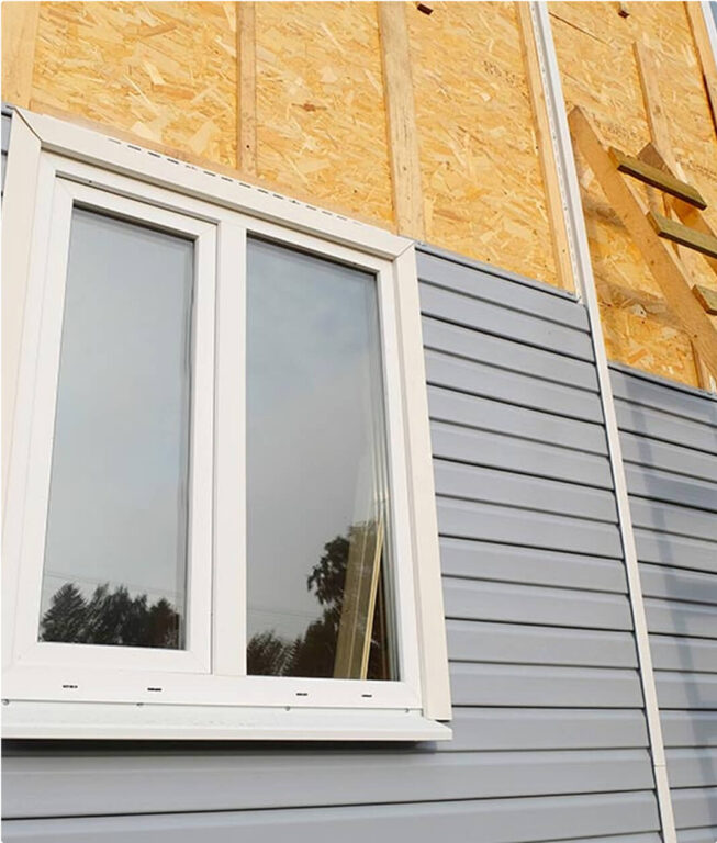 Home exterior with new vinyl siding and window installation showing moisture-proof flashing, illustrating RainWise siding replacement and exterior protection services in Portland