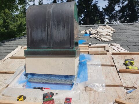 Close-up view of chimney base being prepped with waterproofing materials during leak repair on a Portland home