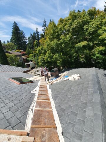 Roofing contractors installing new shingles on a residential roof in Portland during a full roof replacement