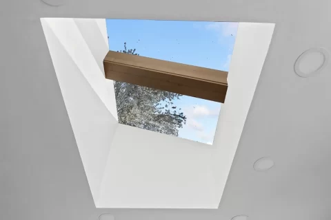 Interior view of a finished skylight shaft with drywall and natural light coming through, showcasing RainWise skylight installation and interior finishing services